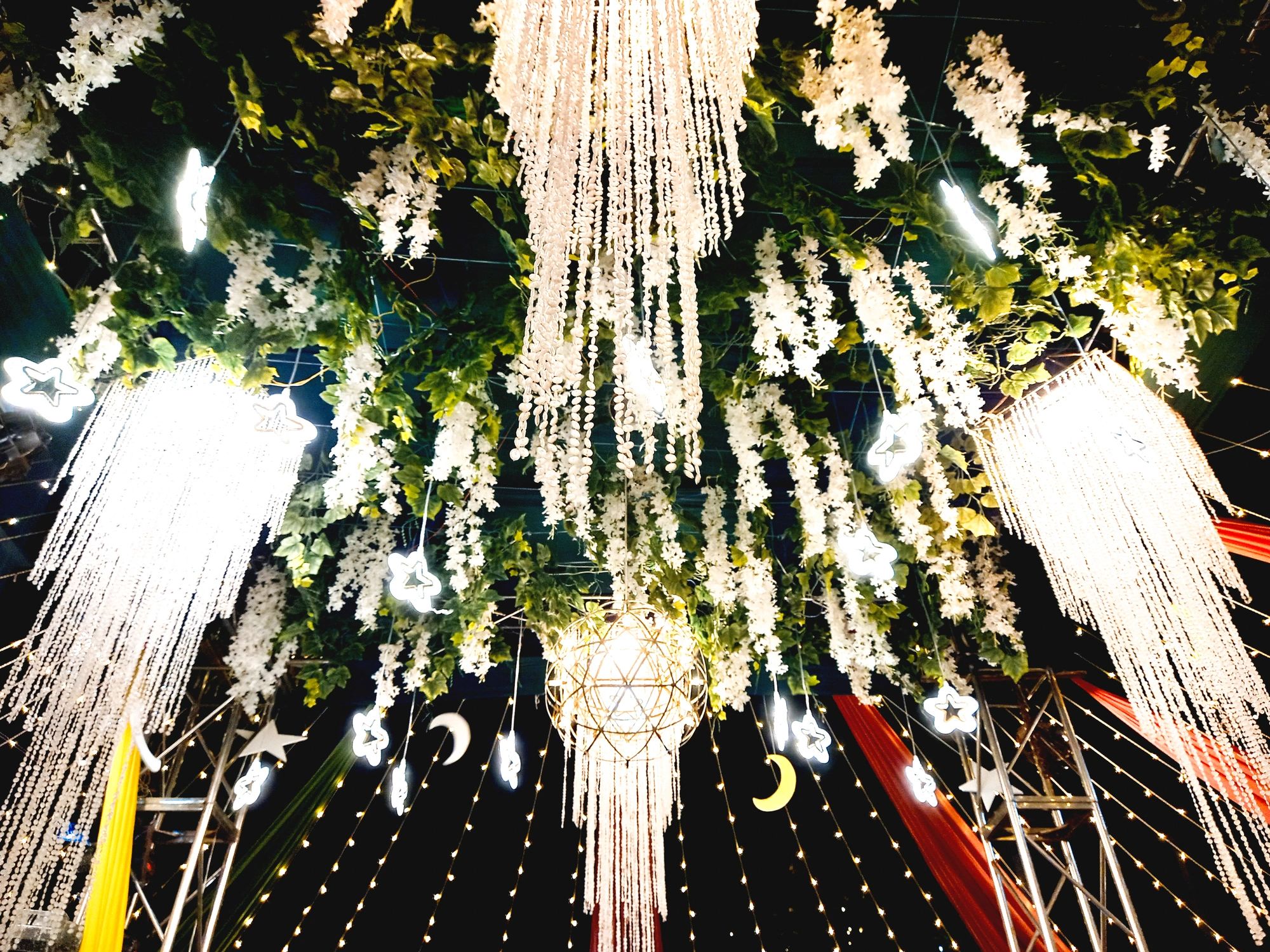 Festive event decor with hanging lights and greenery